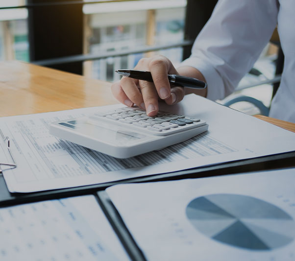 Person using calculator with financial documents on the table
